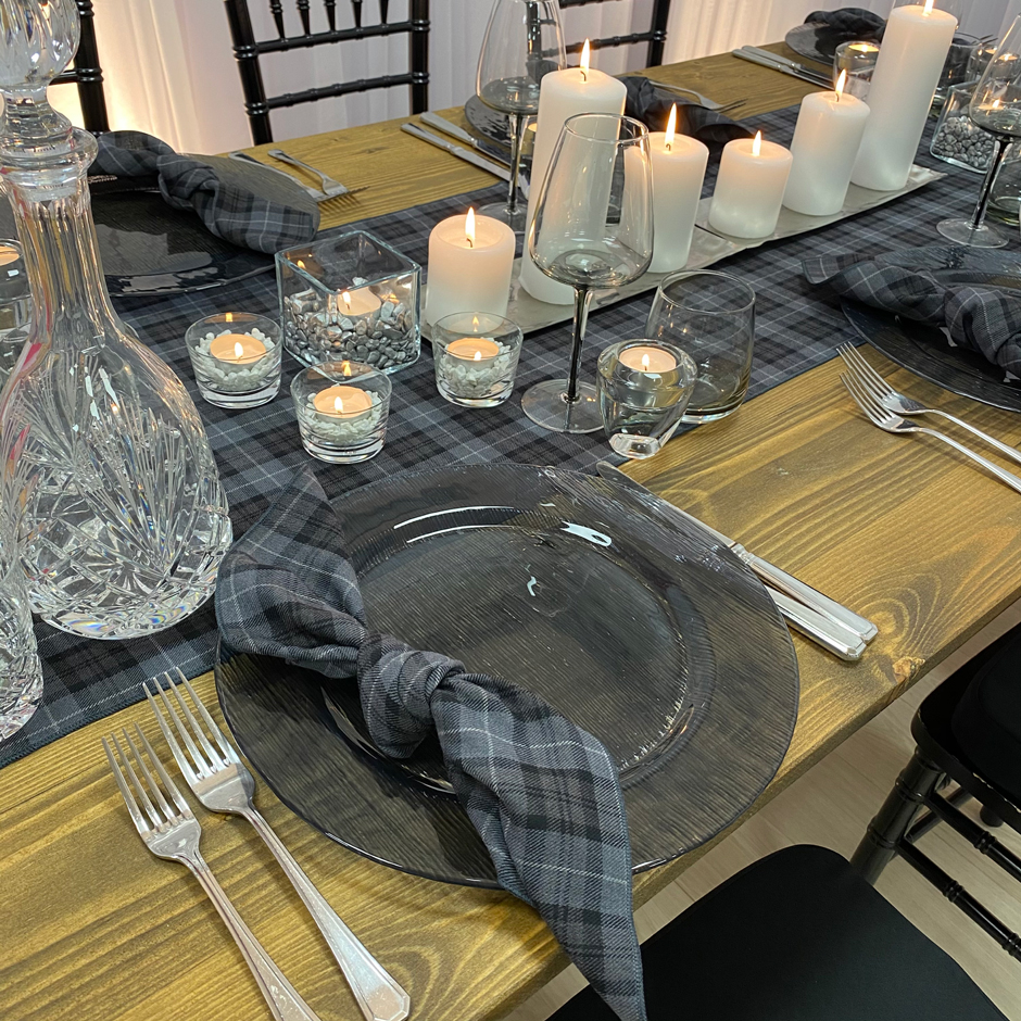 Close up showing detail Arran tartan runner, smoke grey charger and glasses