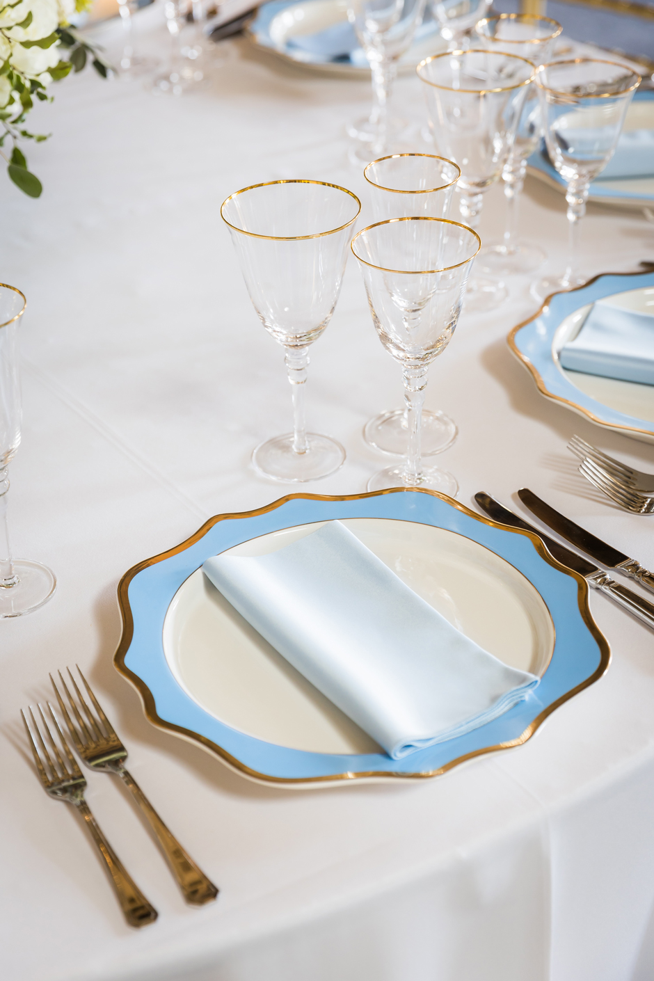 Blue & gold trim Porcelain charegr plate with white Essential linen, powder blue Verona napkin and gold trim glasses.
