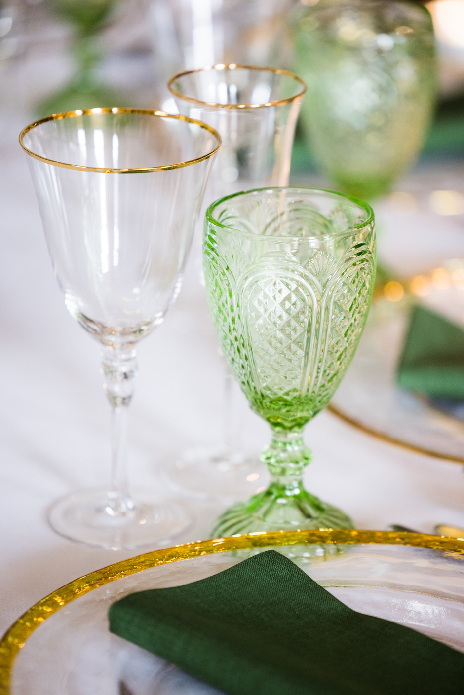 Green goblet with white Essential linen, evergreen Gelato napkin, gold trim charger plate & gold trim glasses